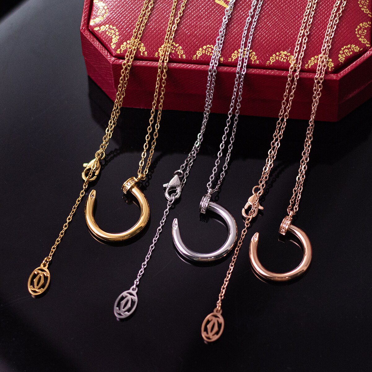 Nail motif pendants and chains shown side by side