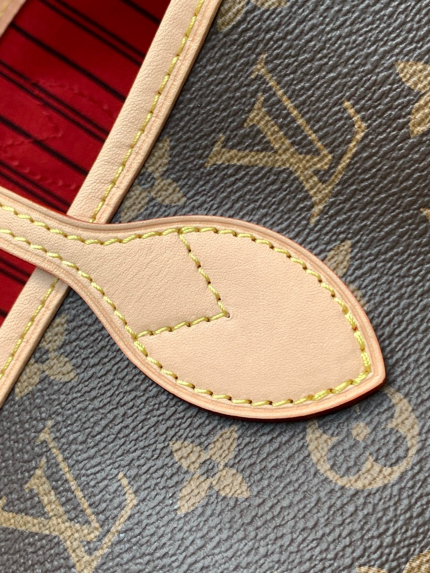 Close view of the handle attachment showing cowhide leather and contrast stitching