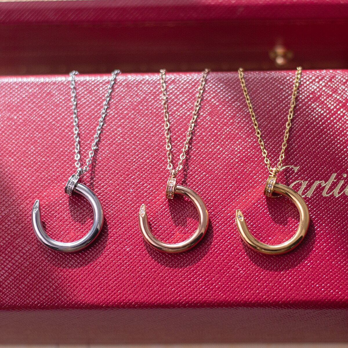 Three finish options of the nail motif pendant necklace displayed together