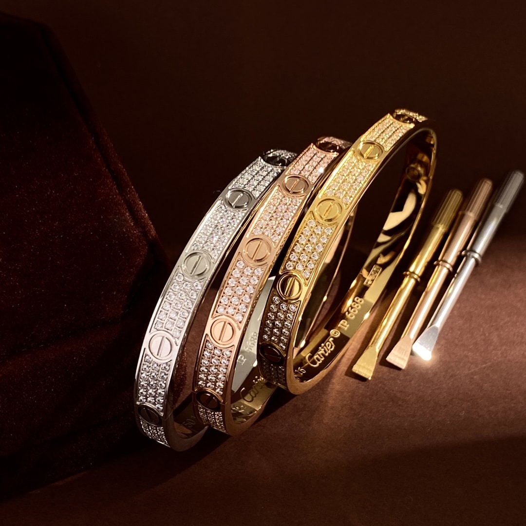Close detail of the three Love Pavé bangles with screwdrivers on a dark backdrop